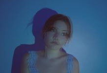 A blurry, blue-tinted photo of a girl who is looking off to the side.