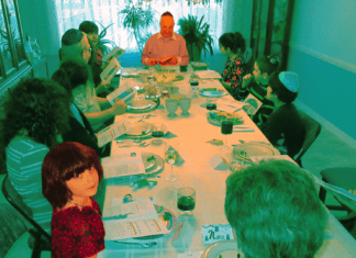 The author looks up from the table while her grandfather leads his last seder before his death in 2017.