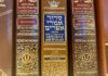 Yismechu A close-up of three siddurim (Jewish prayer books) in shades of red and brown with gold-foiled Hebrew letters on the spine.
